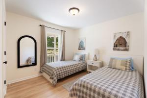 a bedroom with two beds and a mirror at Meadow Farm in Holly Springs, NC in Holly Springs