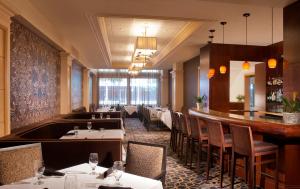 um restaurante com mesas e cadeiras e um bar em The Ashton Hotel em Fort Worth
