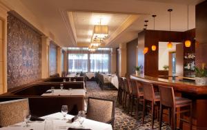 a restaurant with tables and chairs and a bar at The Ashton Hotel in Fort Worth