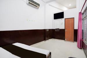 1 dormitorio con 1 cama, TV y puerta en HOTEL O SP GRAND Sidhauli, en Mahmūdābād