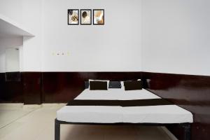 1 cama en una habitación con 3 cuadros en la pared en HOTEL O SP GRAND Sidhauli, en Mahmūdābād