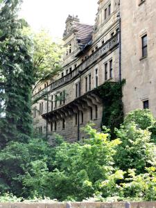 a large building with trees in front of it at Ferienwohnung Snug und Hugley in Neuenstein