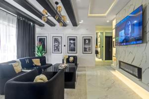 a living room with a couch and a tv at Noir & Blanc Suite in Mama