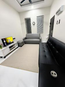 a living room with a couch and a tv at Lunavista Homestay Jitra in Jitra