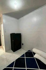 a room with a white wall and a black and white rug at Sewindu in Ramekasan