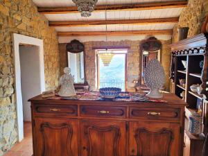 Un gran armario de madera en una habitación con ventana. en Nucidda - Country House with sea & mountain views, en Reitano
