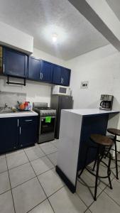 a kitchen with blue cabinets and a white counter top at El Arrecife: Apartamento con alberca a 10 minutos de la playa in Acapulco