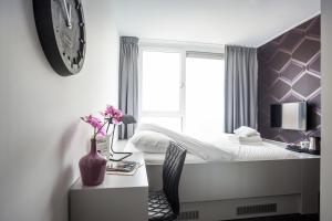um quarto com uma cama e uma secretária com um vaso de flores em Stravinsky Slapen em Hengelo