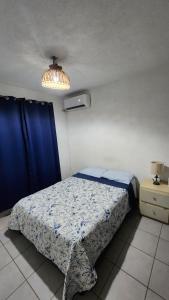a small bedroom with a bed and a light at El Arrecife: Apartamento con alberca a 10 minutos de la playa in Acapulco +10 photos