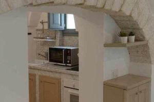 a kitchen with a counter top with a microwave at Trulli Live Alberobello in Alberobello +5 photos
