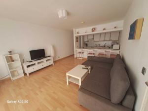 a living room with a couch and a kitchen at Bonito apartamento reformado en Las Coronas in Costa Teguise +32 photos