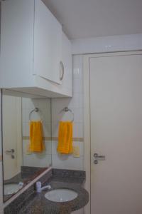 un baño con lavabo y espejo en Ponta Negra_Apto Completo, en Natal