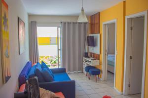 sala de estar con sofá azul y dormitorio en Ponta Negra_Apto Completo, en Natal