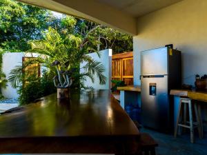 a kitchen with a table and a refrigerator at Villa Privada Merkaba Pxm in Brisas de Zicatela