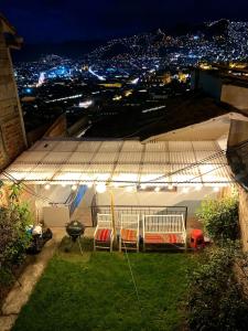 a patio with chairs and a bbq grill under an umbrella at Two-Story San Blas Home with Terrace and Stunning Views in Cusco