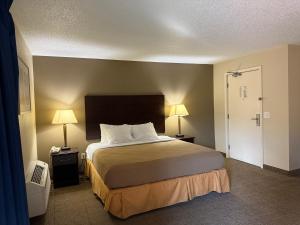 a hotel room with a large bed and two lamps at Clinton Inn & Suites in Port Clinton +109 photos