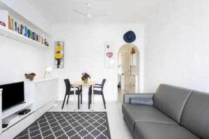 a living room with a couch and a table with chairs at Apartamento Playa San Juan WIFI in Playa de San Juan