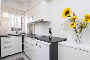 a kitchen with a bottle of wine and flowers on a counter at Apartamento Playa San Juan WIFI in Playa de San Juan +4 photos