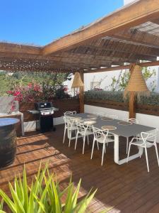 サン・ジョセップ・デ・サ・タライアにあるCasa Bonic -Sunset Seaviewのパティオ(パーゴラの下にテーブルと椅子付)