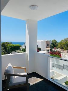 サン・ジョセップ・デ・サ・タライアにあるCasa Bonic -Sunset Seaviewの椅子と大きな窓が備わる客室です。