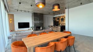 een eetkamer met een houten tafel en oranje stoelen bij Luxury Villa #1 in Stantsiya Mukhiani
