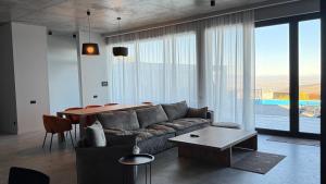 een woonkamer met een bank en een tafel bij Luxury Villa #1 in Stantsiya Mukhiani