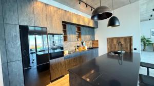 een keuken met een zwarte koelkast en houten kasten bij Luxury Villa #1 in Stantsiya Mukhiani