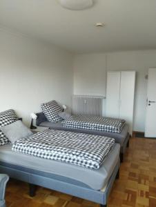 two beds in a room with white walls at Gästezimmer Ilmenaudeich in Winsen Luhe