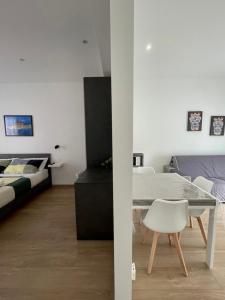 a white room with a bed and a table and a couch at Bedda Apartment in Cefalù