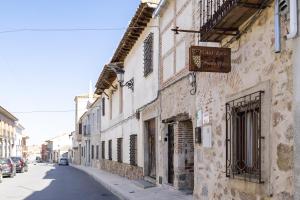 an old building with a sign on the side of a street at Casa Rural Abuelo Pedro in Cuerva