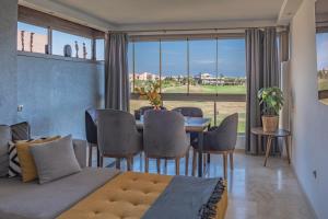 1 dormitorio con mesa y sillas y comedor en Prestigia, superbe appartement, vue sur golf, piscine et Atlas, en Marrakech