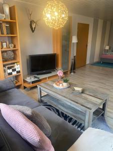 a living room with a coffee table and a tv at Haus Sommerfeld 