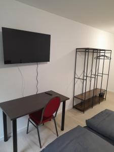 a room with a desk with a television on a wall at Boardinghaus Waldesruh in Lohne