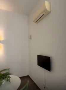 a living room with a tv on a white wall at Casa in Pineta in Follonica