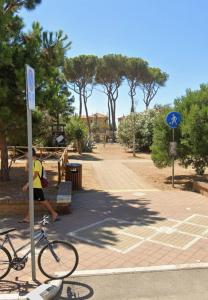 a man standing next to a bike on a street at Casa in Pineta in Follonica