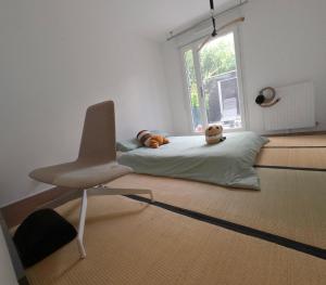 a room with a bed with a chair and a window at Chambre privee in Noisy-le-Sec