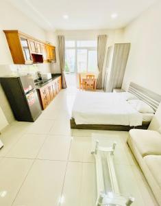 une grande chambre avec deux lits et une cuisine dans l'établissement EMERALD APARTMENTS, à Hô-Chi-Minh-Ville