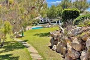 einen Garten mit Felsen und einen Garten mit Pool in der Unterkunft Ponent - Planta baja con vistas al mar y piscinas in Arenal d'en Castell