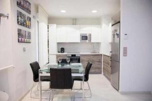 Una cocina con una mesa con sillas y un refrigerador. en Loft San Francisco 26, en Pamplona