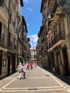 Un grupo de personas caminando por una calle con edificios. en Loft San Francisco 26, en Pamplona