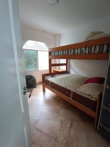 a bedroom with two bunk beds and a window at Apartamento con vista a la playa frente al mar in El Recreo