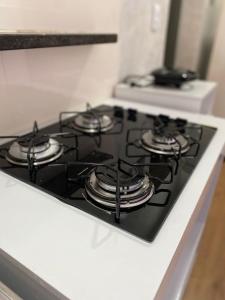 a stove top oven with four burners on it at Apartamento compartilhado em Guarapuava - Quarto 2 in Guarapuava +56 photos