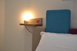 トッレ・ラピッロにあるApartments 3.0のベッドと青い椅子の横にライト
