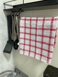 a red and white towel hanging on a kitchen counter at Apartamento compartilhado em Guarapuava - Quarto 2 in Guarapuava