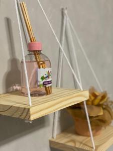 a wooden shelf with a jar of honey and a plant at Apartamento compartilhado em Guarapuava - Quarto 2 in Guarapuava