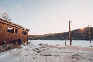 a snow covered road next to a building with a field of snow at Twin Cottages with Mountain & Lake View in Morin Heights +38 photos