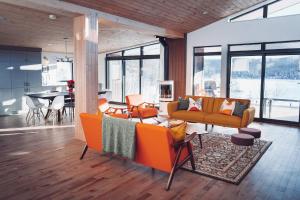 a living room with orange couches and a table at Twin Cottages with Mountain & Lake View in Sainte-Adèle +41 photos