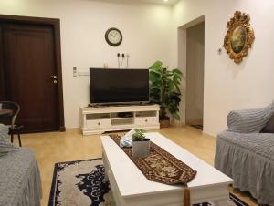 a living room with a flat screen tv on a entertainment center at موني للشقق الفندقية in Qabāʼ
