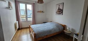 a bedroom with a bed and a large window at Au coeur de Dieppe, au puits salé BY HOLIDIEPPE in Dieppe