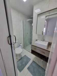 a bathroom with a sink and a shower and a toilet at Apartamento Dona Elvira in Piçarras +44 photos